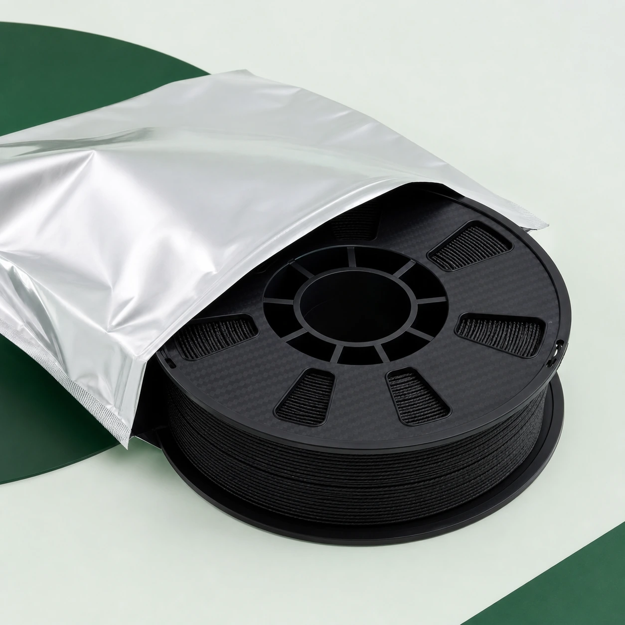 Black PAHT-CF: unbranded black PAHT-CF spool partly inside a plain silver moisture-barrier bag