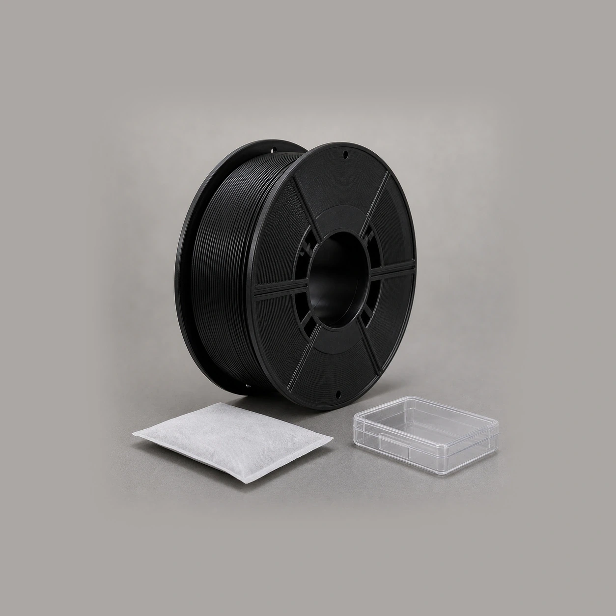 Black PAHT-CF: unbranded black PAHT-CF spool beside a plain moisture-control sachet and a sealed transparent humidity-indicator case with