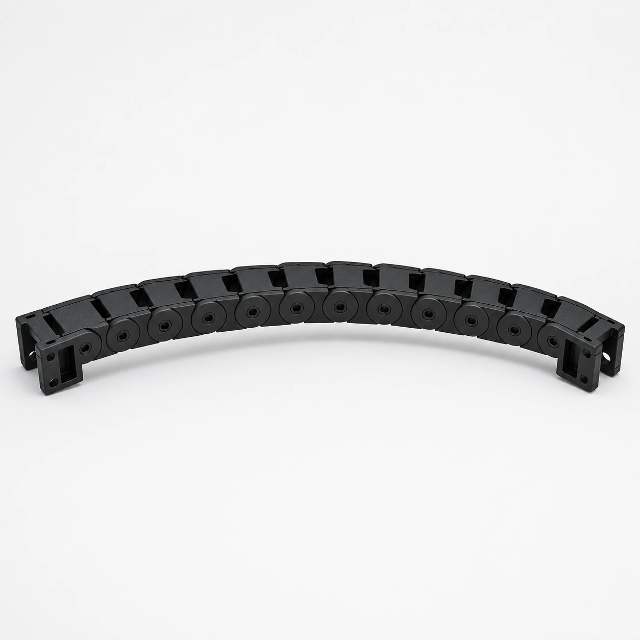 Black PAHT-CF: articulated cable-chain segment curved into a shallow arc with every link connected
