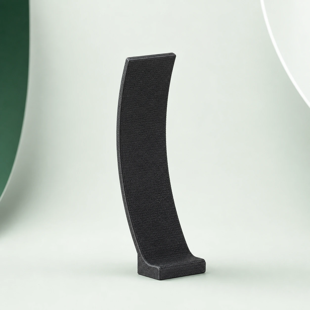 Black PAHT-CF: curved thin-wall coupon on an integrated foot, showing uninterrupted fine FDM layers