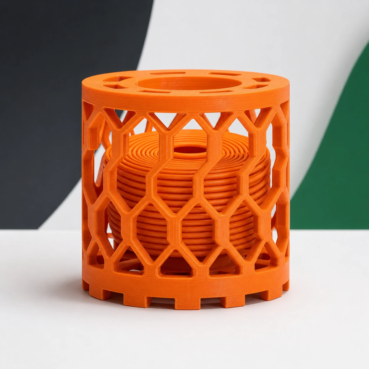 orange PLA Tough+ complete moisture-review lattice cage holding a loose coil-shaped printed insert, entirely 3D printed plastic