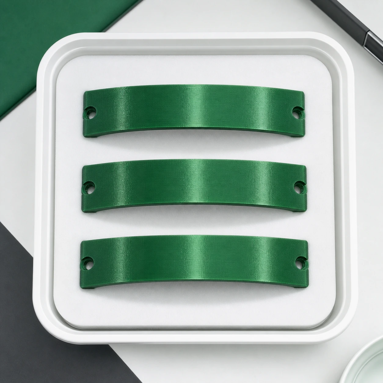 Green PLA Silk+ three complete matching curved retained sample coupons arranged in a clean laboratory tray for repeat review