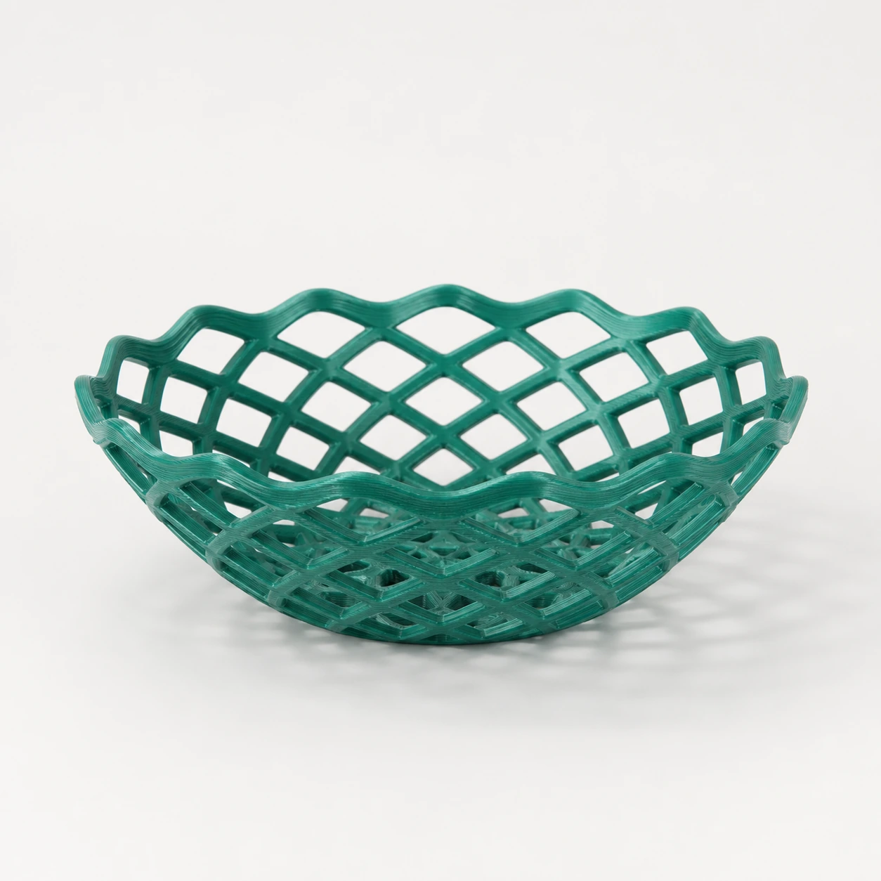 Teal PLA Silk+ open-lattice fruit bowl with an undulating rim